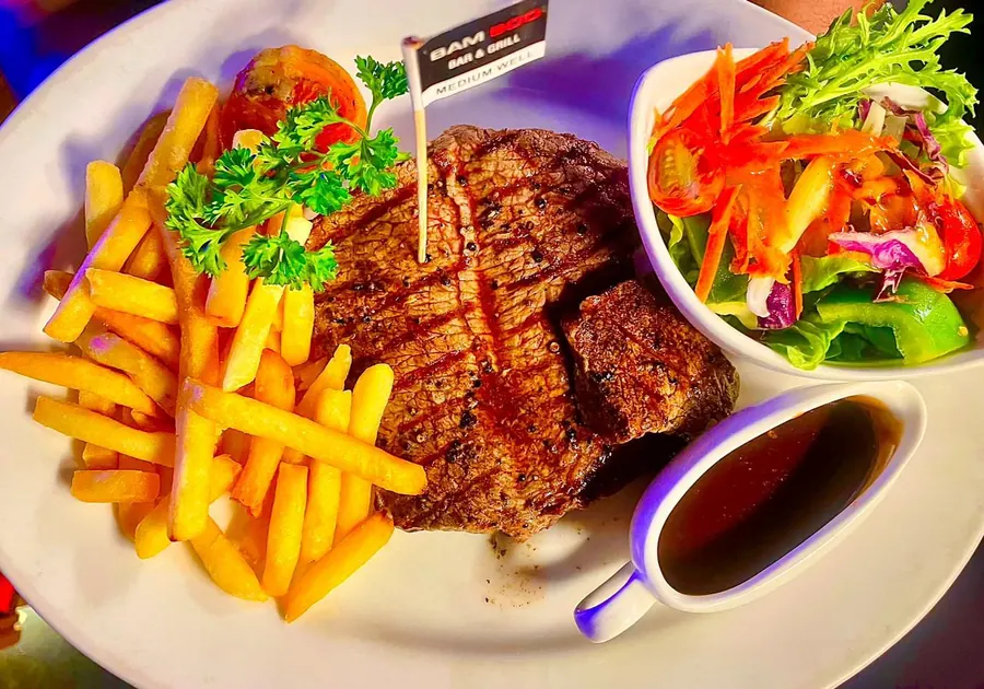 T-bone steak straight off the Bamboo grill with chips, salad and gravy